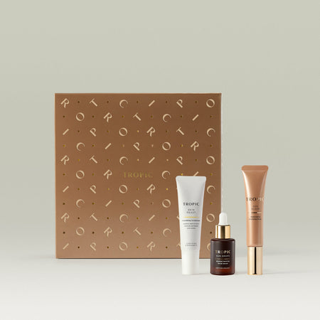 Tropic Skincare gift set titled The Healthy Glow Ritual – natural bronzing trio, featuring Skin Feast nourishing moisturiser, Sun Drops tanning serum, and Sun Glaze illuminating bronzing drops, presented alongside a bronze-toned gift box with metallic detailing.